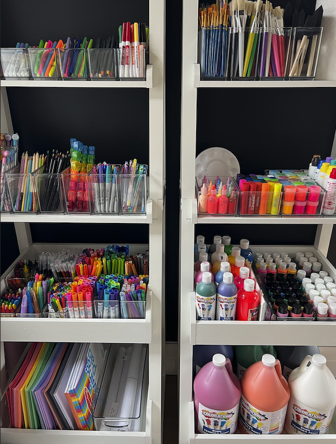 Organized children’s art supplies arranged in clear containers on shelving