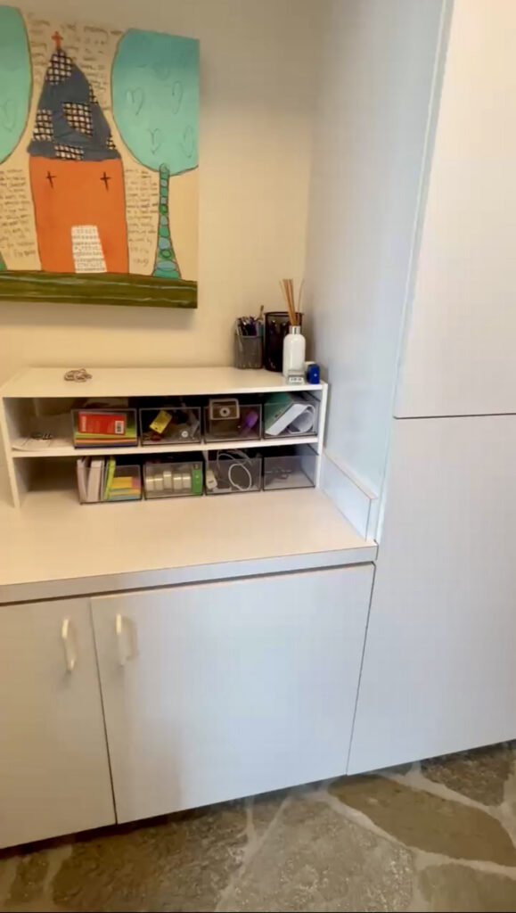 Organized homework and craft station with art supplies stored above a built-in desk